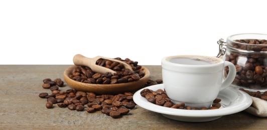Cup of aromatic hot coffee and beans on wooden table against white background