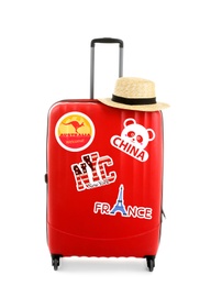 Image of Modern suitcase with travel stickers and hat on white background