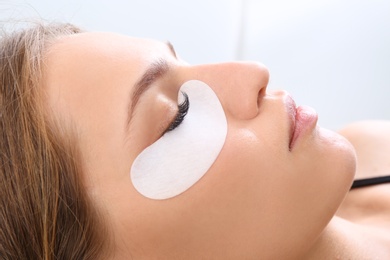 Young woman undergoing eyelash extensions procedure, closeup