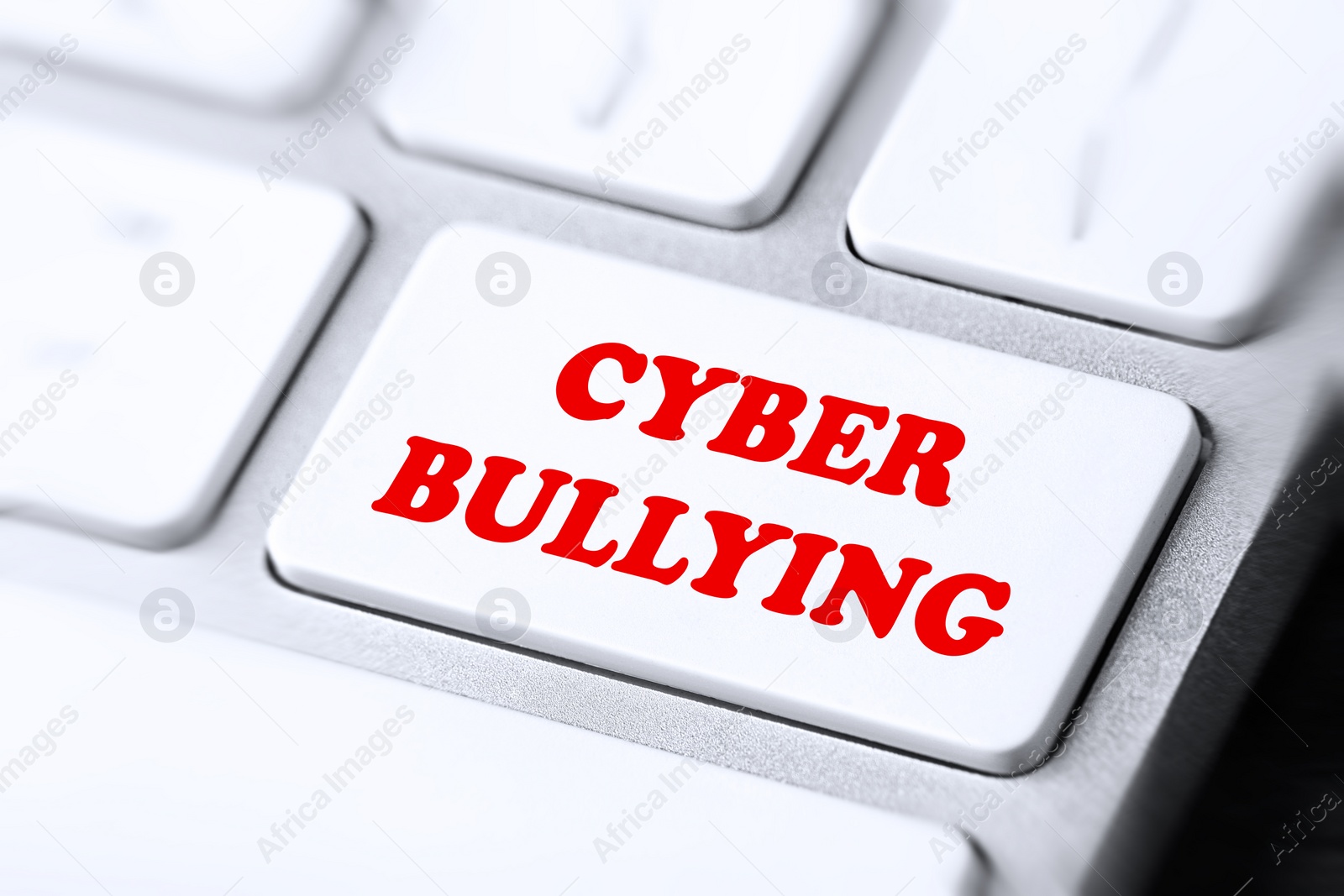 Image of Modern computer keyboard with phrase CYBER BULLYING on white button, closeup