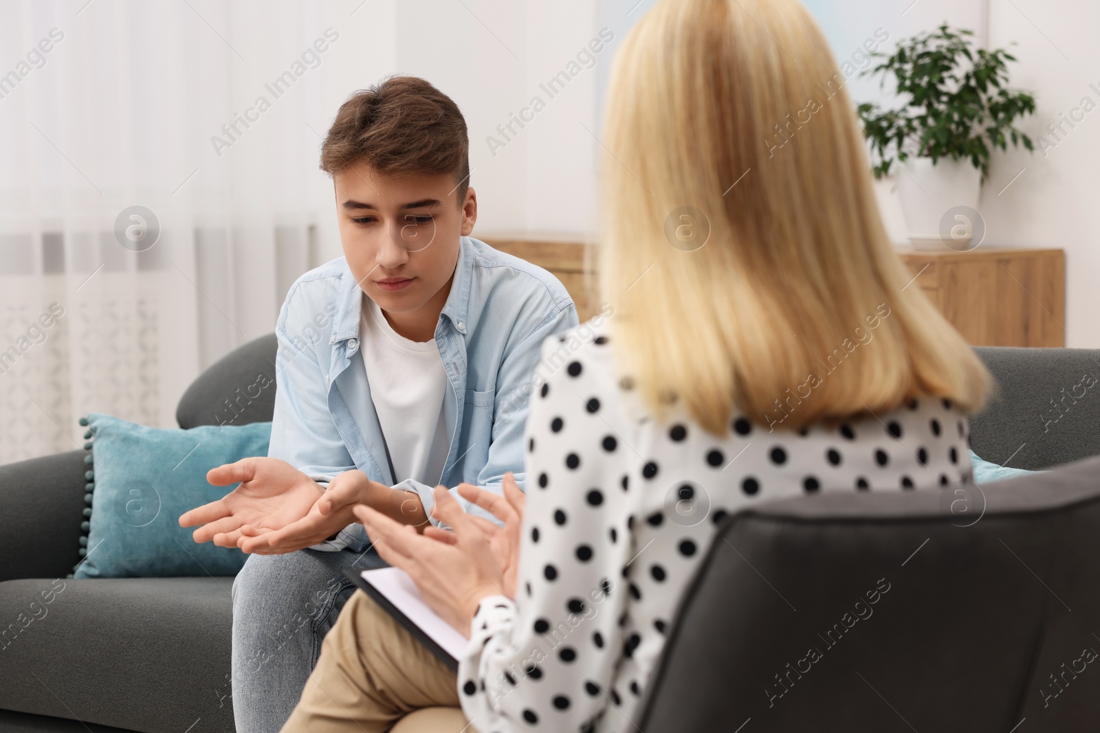 Photo of Psychologist working with teenage boy in office