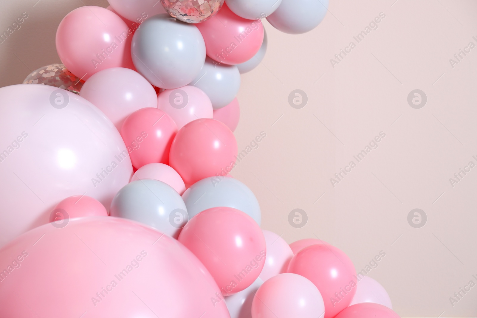 Photo of Beautiful composition with balloons on beige background, closeup. Space for text