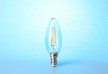 Photo of New modern lamp bulb on light blue background