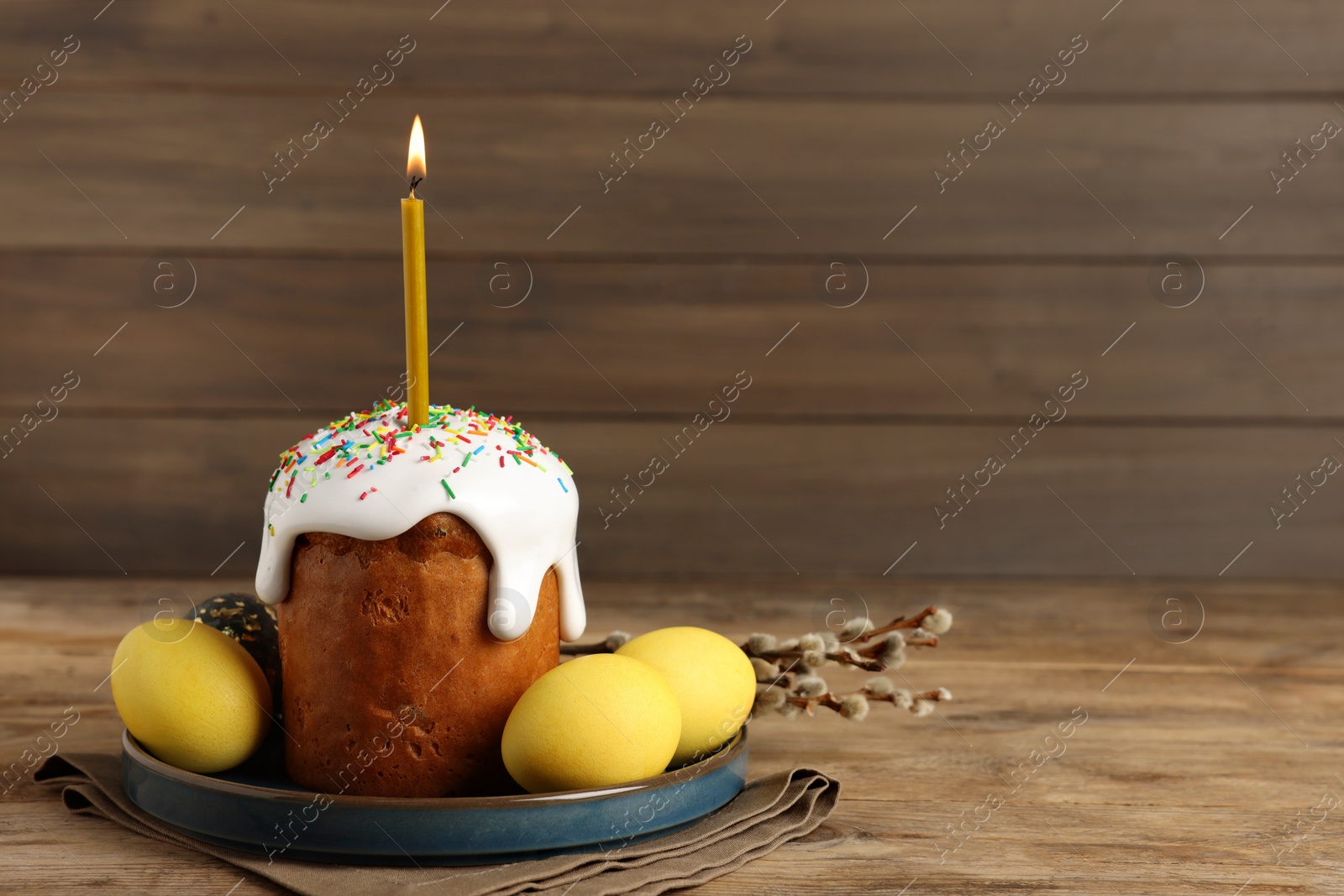Photo of Tasty Easter cake, decorated eggs and willow branches on wooden table. Space for text