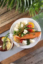 Photo of Healthy meal. Piece of tasty grilled salmon with vegetables and glass of refreshing drink on wooden table, top view