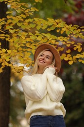 Photo of Portrait of happy woman wearing warm sweater in autumn park