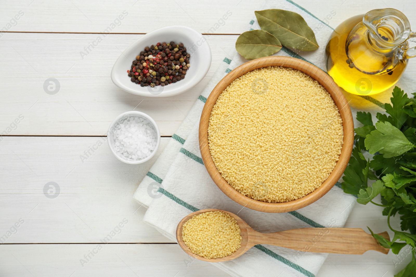 Photo of Raw couscous and ingredients on white wooden table, flat lay. Space for text