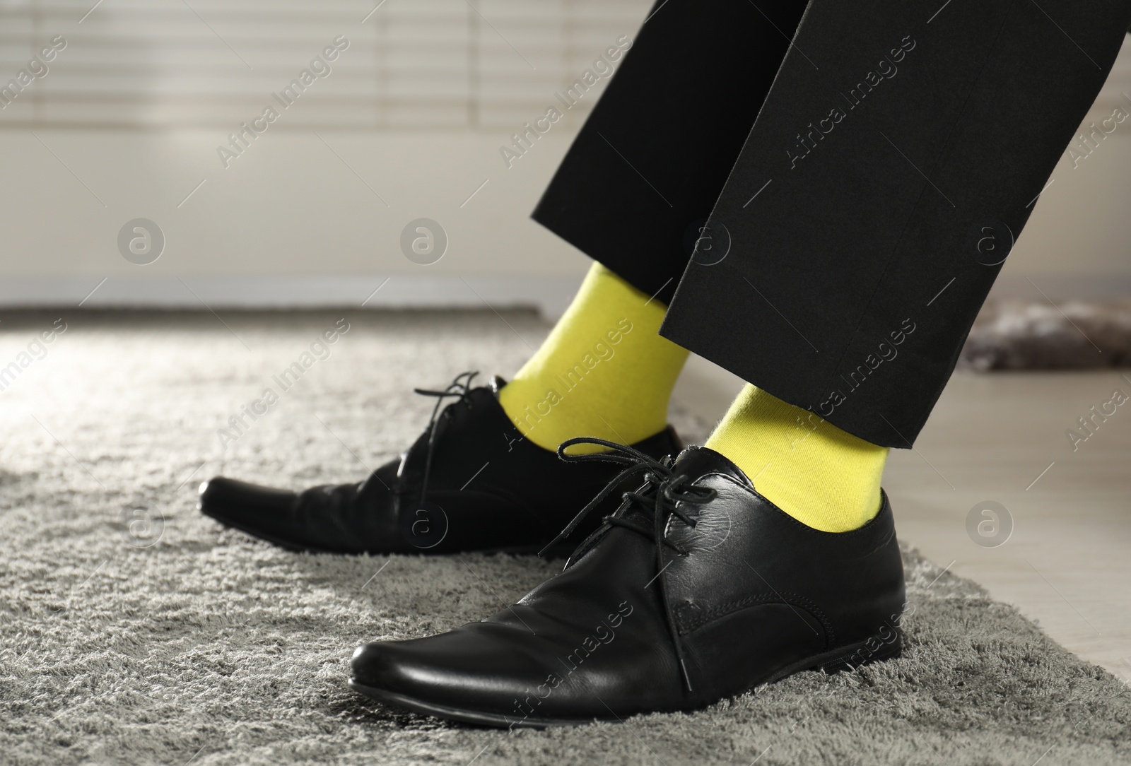 Photo of Man wearing stylish shoes and yellow socks indoors, closeup