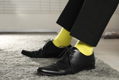 Man wearing stylish shoes and yellow socks indoors, closeup