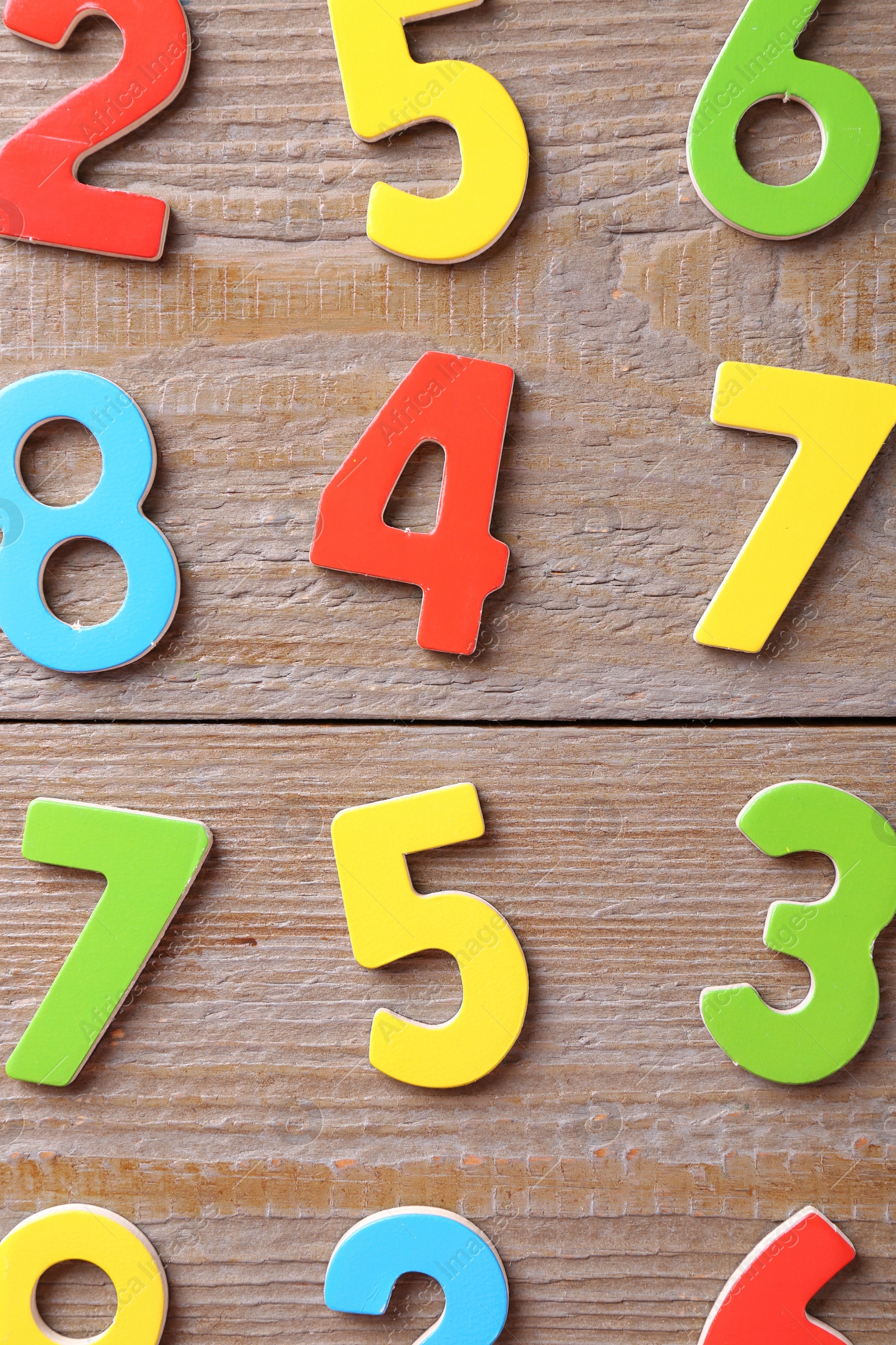 Photo of Colorful numbers on wooden table, flat lay