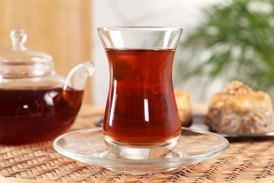 Traditional Turkish tea in glass on wicker table, closeup