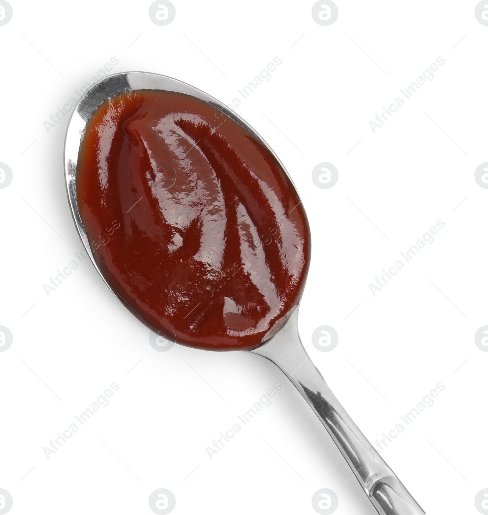 Photo of Tasty barbecue sauce in spoon isolated on white, top view