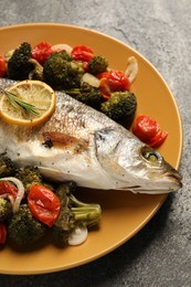 Photo of Delicious baked fish and vegetables on grey background