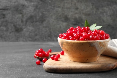 Tasty ripe cranberries on black table, space for text