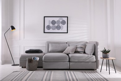 Photo of Cozy living room interior with comfortable grey sofa and beautiful picture
