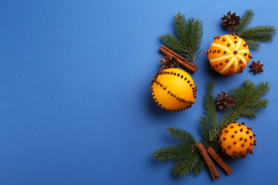 Photo of Flat lay composition with pomander balls made of fresh tangerine and oranges on blue background. Space for text