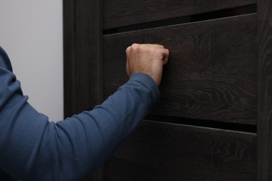 Photo of Collection agent knocking on wooden door, closeup