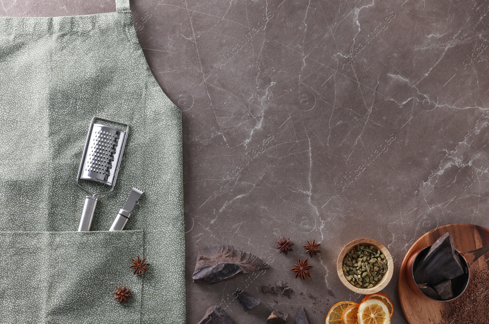 Photo of Clean apron with kitchen tools and different ingredients on brown marble table, flat lay. Space for text