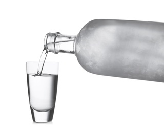 Photo of Pouring vodka into shot glass on white background