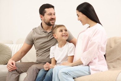 Happy pregnant woman spending time with her son and husband at home