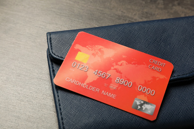 Photo of Credit card and wallet on grey table, closeup