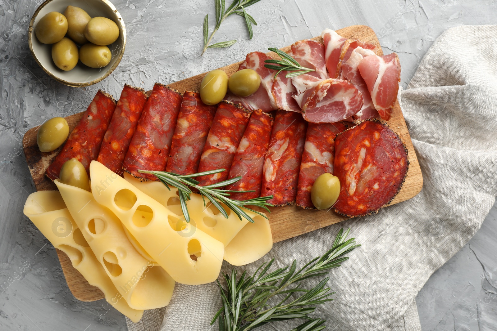 Photo of Delicious charcuterie board served on light grey table, flat lay