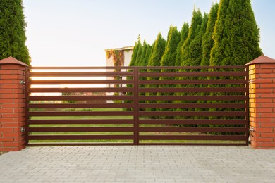 Photo of Beautiful brick fence with iron panels outdoors