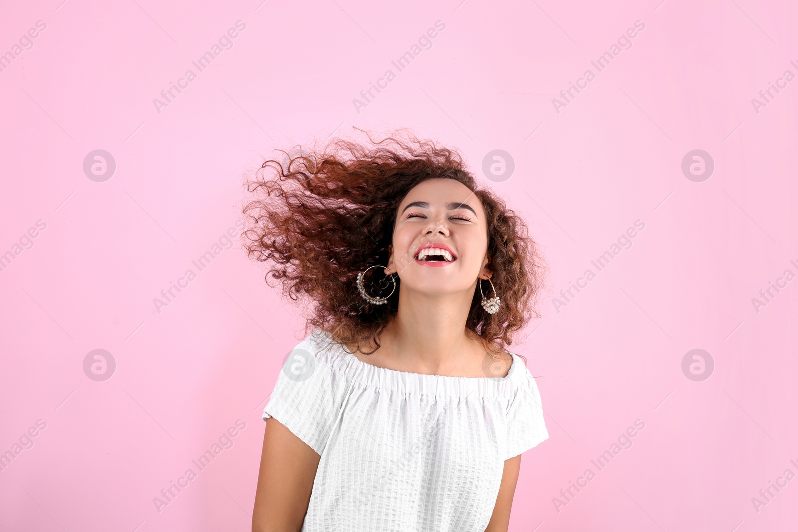 Photo of Portrait of young laughing African-American woman on color background