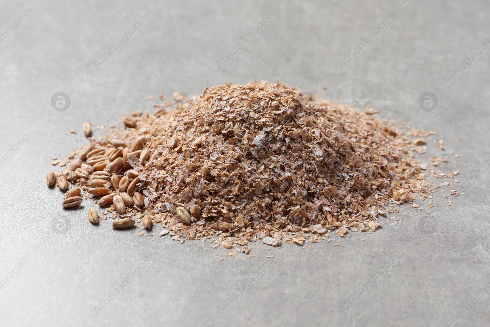 Photo of Pile of wheat bran on grey table