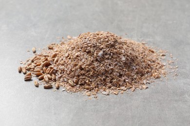 Photo of Pile of wheat bran on grey table