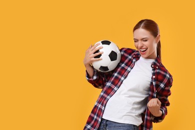 Photo of Emotional fan holding football ball and celebrating on yellow background, space for text
