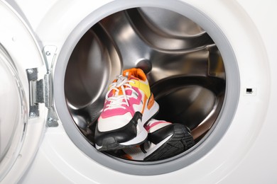 Photo of Different clean sneakers inside modern washing machine