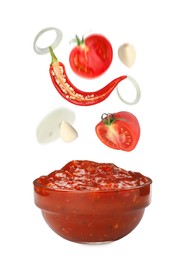Image of Different ingredients falling into glass bowl with delicious adjika sauce on white background