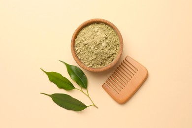 Photo of Henna powder, green leaves and comb on beige background, flat lay. Natural hair coloring