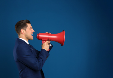Photo of Handsome man with megaphone on blue background