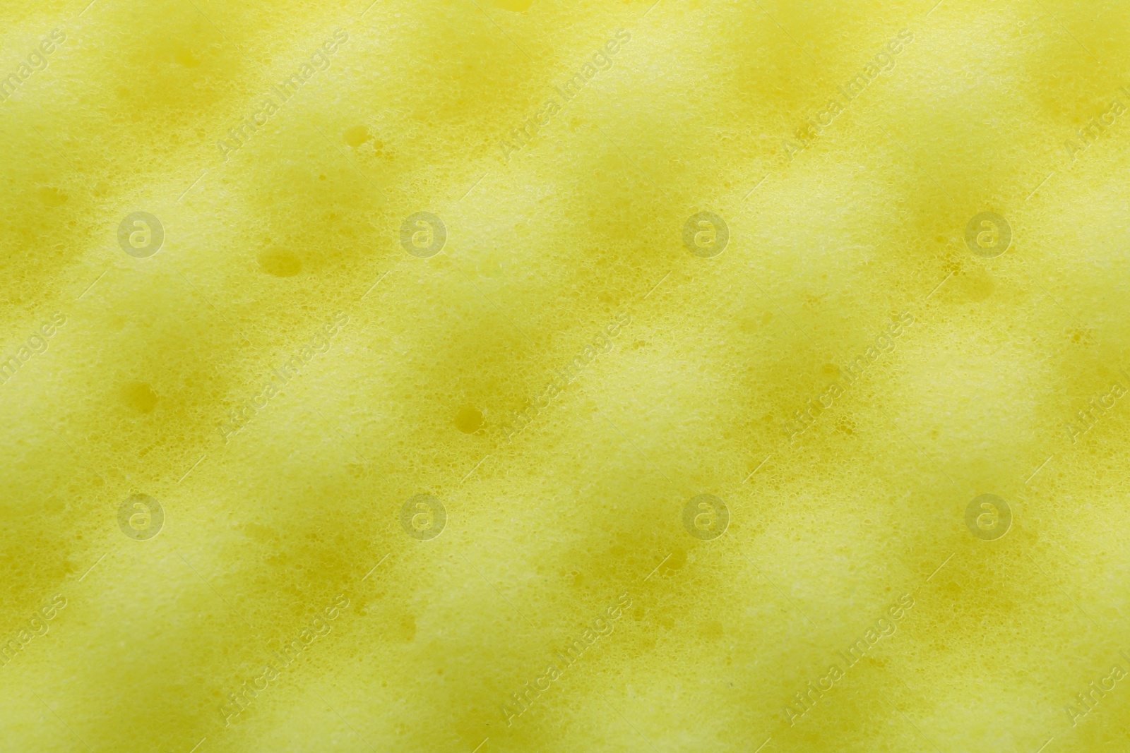 Photo of Yellow cleaning sponge as background, top view