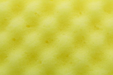 Yellow cleaning sponge as background, top view