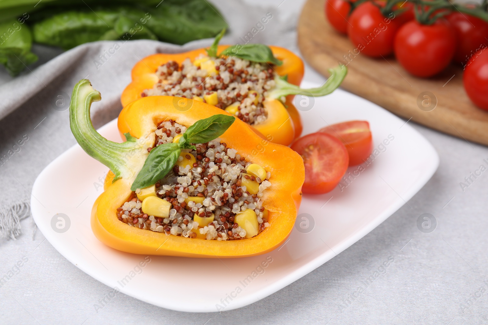 Photo of Quinoa stuffed bell pepper with basil on light table, closeup