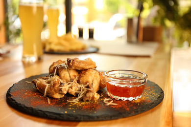 Photo of Tasty BBQ wings served on table in cafe