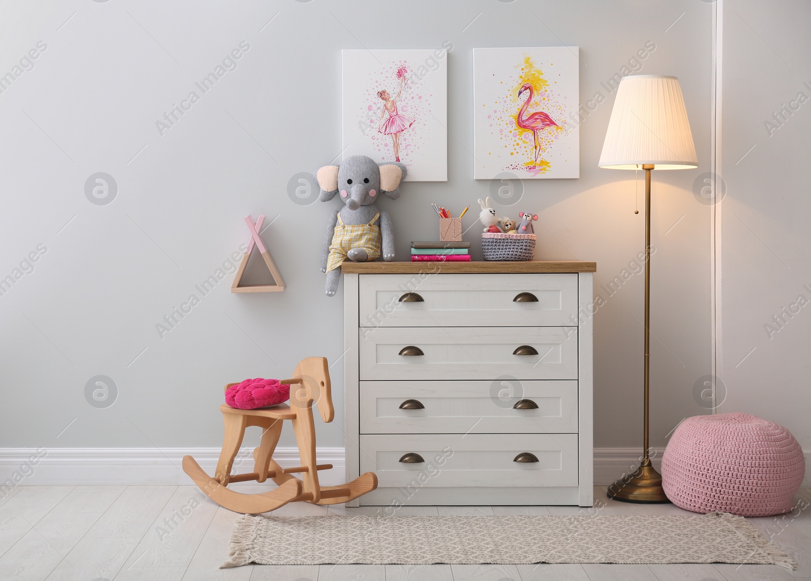 Photo of Chest of drawers and beautiful pictures in children's room. Interior design