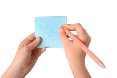 Child erasing drawing of sun with erasable pen against white background, closeup