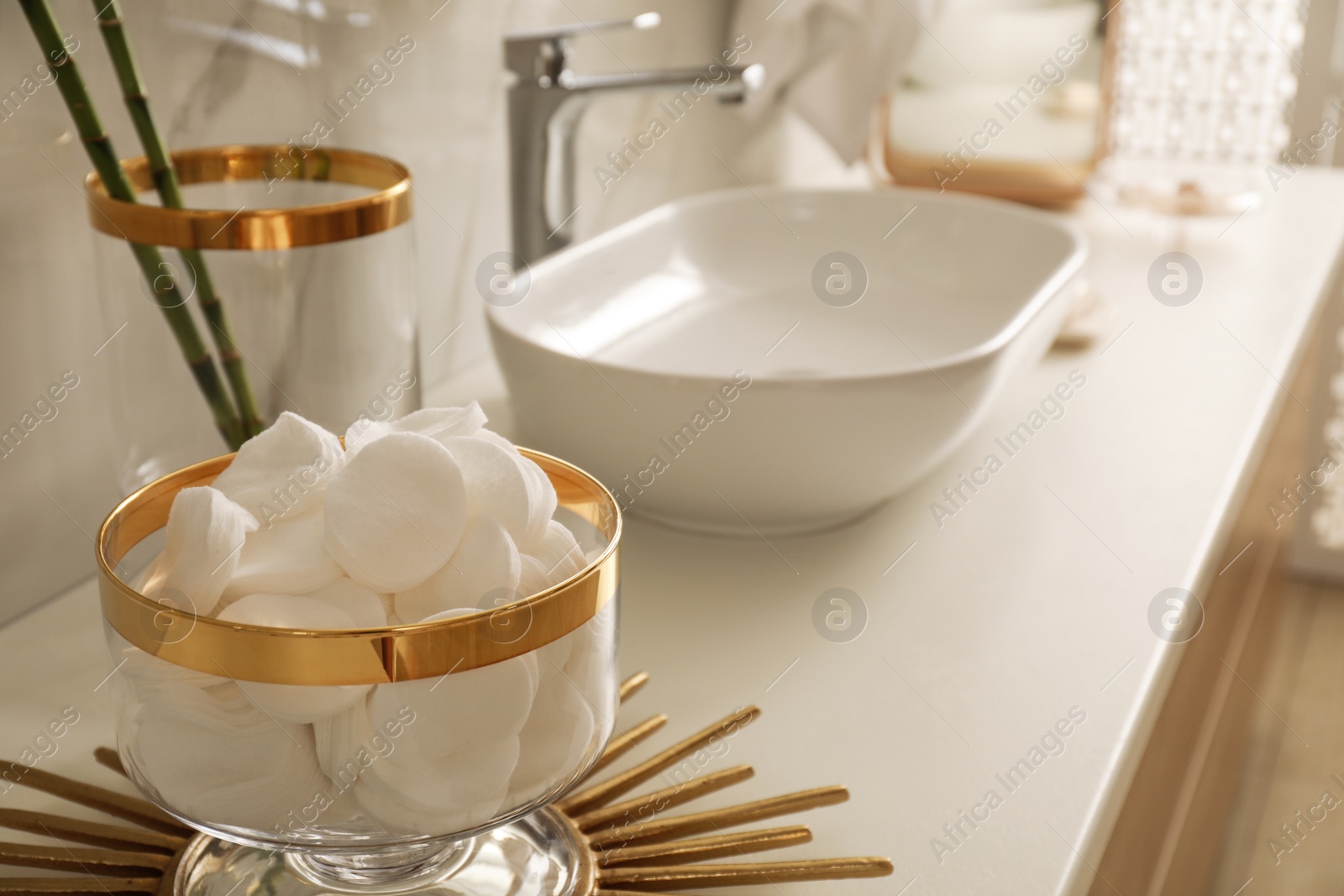 Photo of Decorative jar with cotton pads on modern countertop in bathroom interior