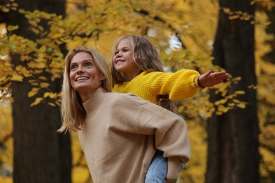 Happy mother with her daughter in autumn park