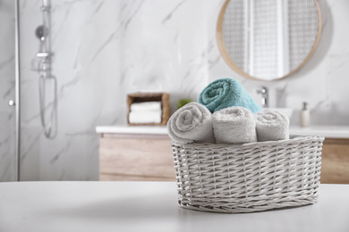 Photo of Wicker basket with clean soft towels in bathroom. Space for text