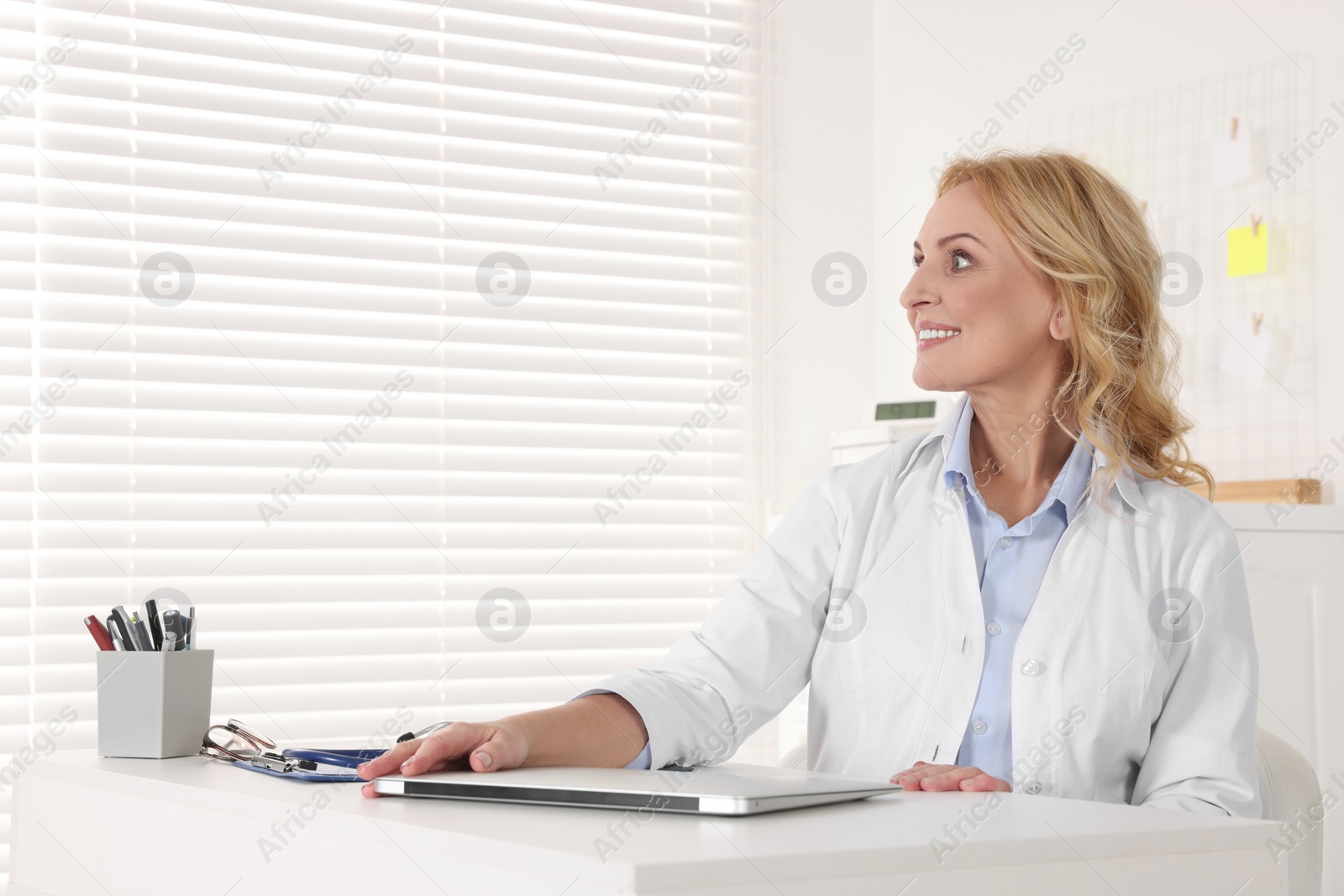 Photo of Doctor with laptop at workplace in clinic. Online medicine concept