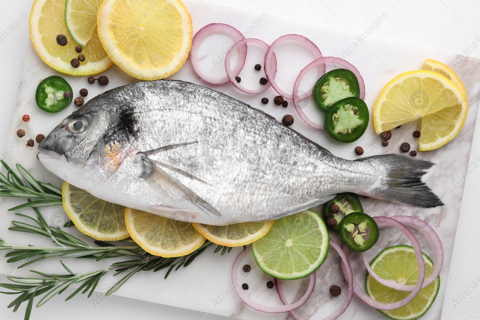 Photo of Fresh dorado fish and spices on white table, top view