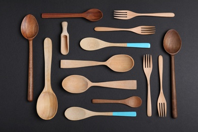 Set of new wooden cutlery on black background, flat lay