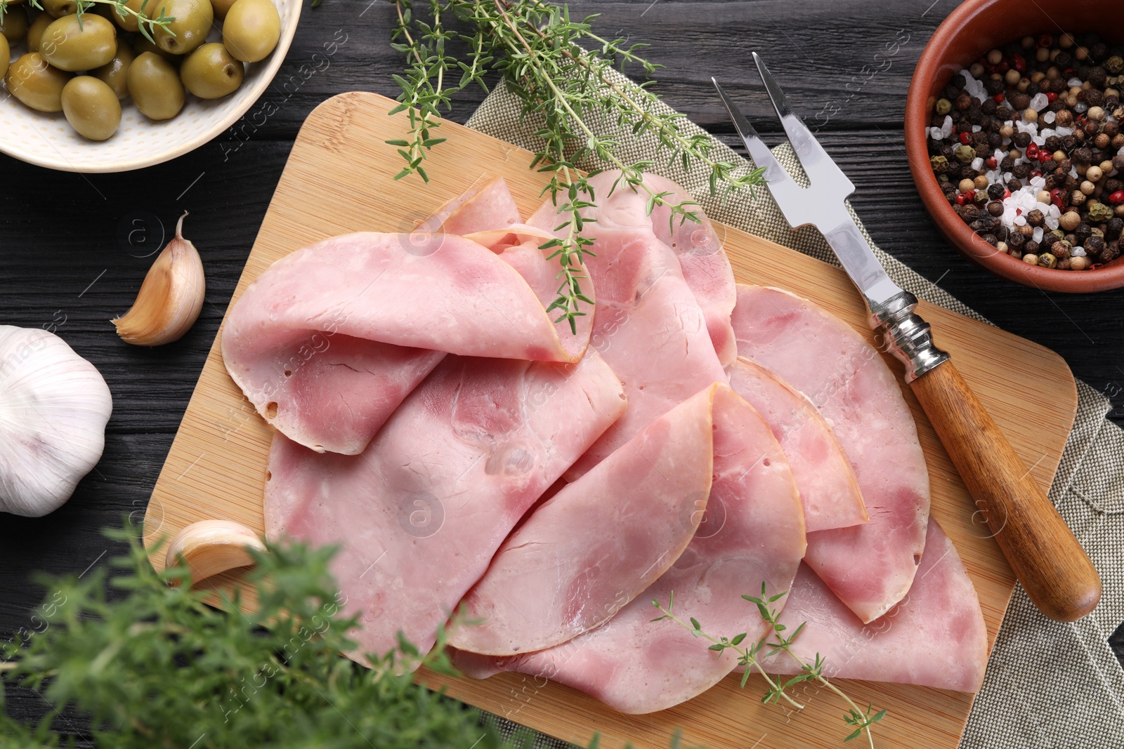 Photo of Slices of delicious ham served with different ingredients on dark wooden table, flat lay