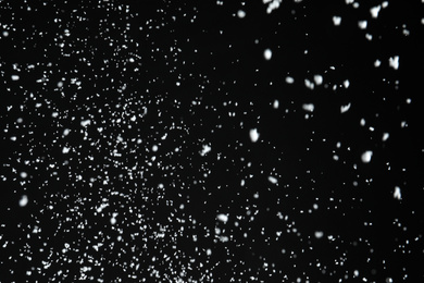 Photo of White snow falling down on black background