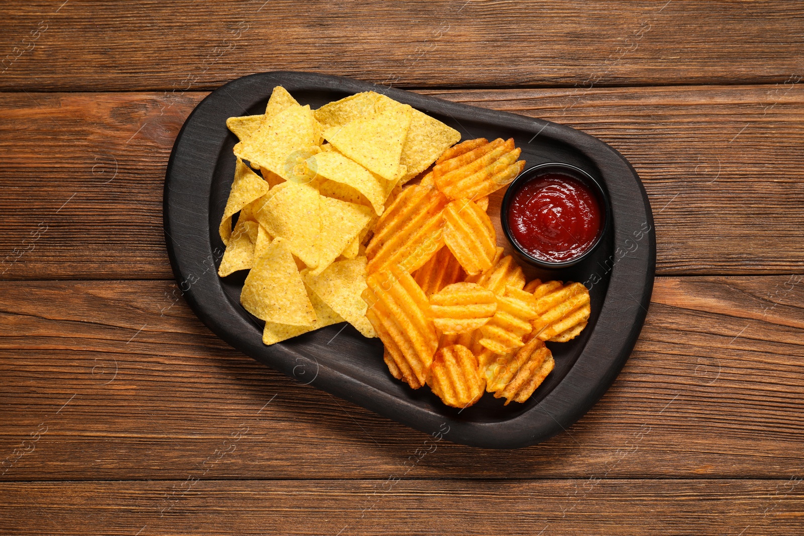 Photo of Tasty tortilla and ridged chips with ketchup on white wooden table, top view